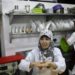 A hearing impaired employee uses sign language to communicate with a co-worker in the kitchen of a restaurant in Gaza