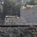 Girl sits on a railway track as she looks to cross the border fence from the northern Syrian town of Ras al-Ain into Turkey, as seen from the Turkish border town of Ceylanpinar