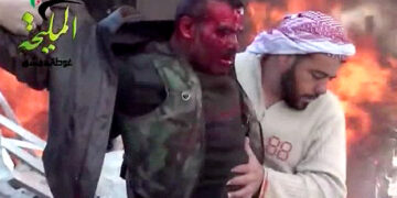 A bleeding man emerges from a bombed petrols station in Damascus