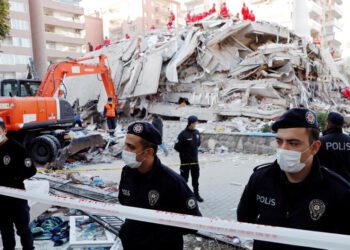 Police officers stand next to debris during rescue operations after an earthquake struck the Aegean Sea, in the coastal province of Izmir, Turkey, on October 31, 2020. (Reuters)