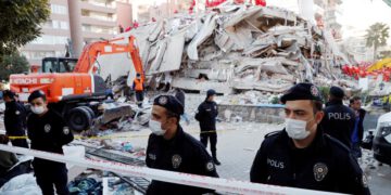 Police officers stand next to debris during rescue operations after an earthquake struck the Aegean Sea, in the coastal province of Izmir, Turkey, on October 31, 2020. (Reuters)
