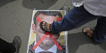 A man steps on a defaced portrait of Emmanuel Macron during a protest on Monday outside the French embassy in Jakarta, Indonesia. Photograph: Dita Alangkara/AP